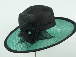 Wide brimmed black and emerald parasisal straw featuring stitched wild silk flower and ribbon trim.