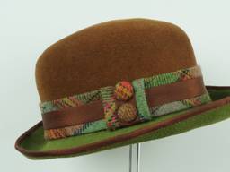 A flattering colour combo on this velour hat with tweed, ribbon and covered button trim.