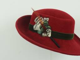 Green velvet ribbon and feather trim accent this poppy red velour with upturned brim